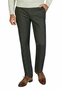 Schlanke, dunkelgraue Hose aus strukturiertem Stoff mit seitlichen Taschen, kombiniert mit braunen Dressschuhen mit kontrastierendem Zehenkappen.