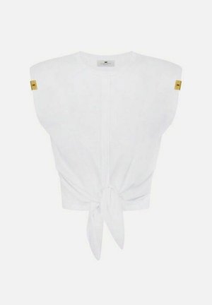 Top bianco senza maniche con spalle imbottite, nodo frontale e piccoli tag dorati su ogni spalla.