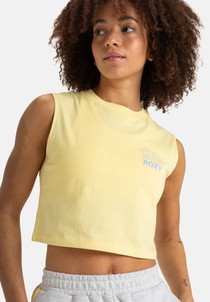 Yellow cropped sleeveless t-shirt made of soft fabric; features a blue graphic "90 Roxy" on the chest. Simple round neckline, relaxed fit.