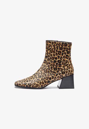 Leopard print ankle boot with a pointed toe, made of textured material, featuring a black block heel and a smooth finish.