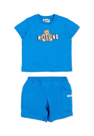 Jasnoniebieski strój dla małego dziecka z krótkimi rękawami i szortami, z misiem i logo "Moschino" na koszulce i kieszeni.
