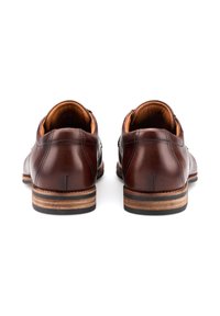 Scarpe in pelle marrone con una finitura liscia, caratterizzate da una forma arrotondata e un tacco stratificato in legno e gomma. L'interno è foderato con un tessuto beige.