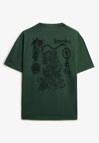 Groene katoenen T-shirt met een zwarte tijgerafbeelding, bamboe en tekst op de achterkant. Korte mouwen, ronde hals en een ontspannen pasvorm.