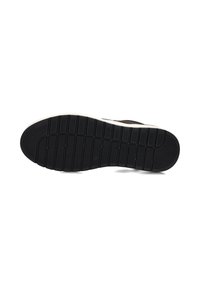 Zwarte rubberen zool met een textuurpatroon en een witte tussenzool, gekenmerkt door een gebogen vorm en diepe groeven voor grip.