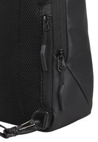 Black backpack featuring a combination of smooth leather and textured mesh. Includes dual zippers and a clip attachment at the base.
