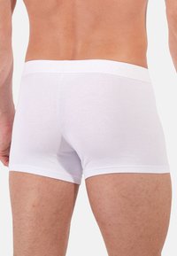 Białe bawełniane slipy z miękkim elastycznym pasem w talii z detalami logo; dopasowany krój z gładką fakturą i bez widocznych wzorów.