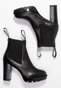 Black leather ankle boots with elastic side panels, textured block heels, and pull tabs. Features a smooth finish and a rugged sole design.