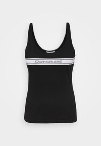 Černý tílko vyrobené z bavlny s kulatým výstřihem, s bílým horizontálním pruhem, na kterém je ve středu vytištěno "CALVIN KLEIN JEANS".