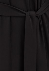 Fekete ruha, derékban megkötővel, sima, puha anyagból, finom redőkkel a textúra és forma érdekében.