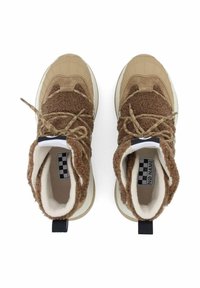 Braune Sneakers mit einem strukturierten, flauschigen Obermaterial und einer Gummisohle, ausgestattet mit sandfarbenen Akzenten, gemusterten Schnürsenkeln und einem schwarzen Label mit weißer Beschriftung.