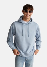 Felpa con cappuccio blu chiaro realizzata in morbido cotone misto, dotata di coulisse, polsini a costine e un piccolo logo sul petto.