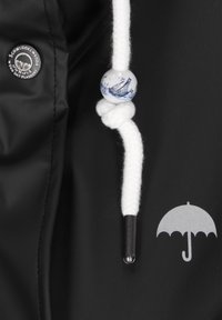 Czarna nieprzemakalna tkanina ma biały pleciony sznurek, akcentowany dekoracyjną niebiesko-białą koraliką przedstawiającą żaglowiec. Srebrne logo parasola.