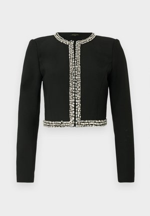 Black cropped jacket with long sleeves, adorned with a row of silver rhinestones along the neckline and hem, creating a structured design.