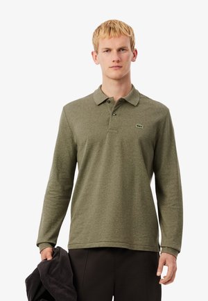 Polo à manches longues vert olive en tissu texturé avec une patte de boutonnage à trois boutons, arborant un petit logo brodé sur la poitrine.
