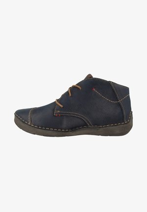 Bottine en cuir bleu foncé avec des lacets marron, des coutures beiges et une semelle en caoutchouc usée, vue de côté extérieur.