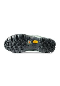 Terrängskos sula med djup, robust svart gummiprofil; har Vibram-logotyp och texturerad yta för grepp; accentfärger i grönt och grått.