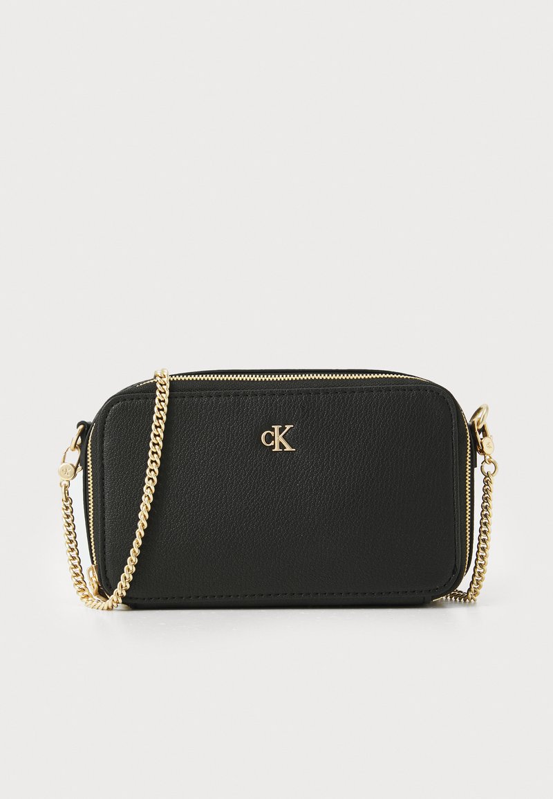 Black leather bag with a textured finish, gold chain strap, dual zip closure, and embossed logo. Compact rectangular design.