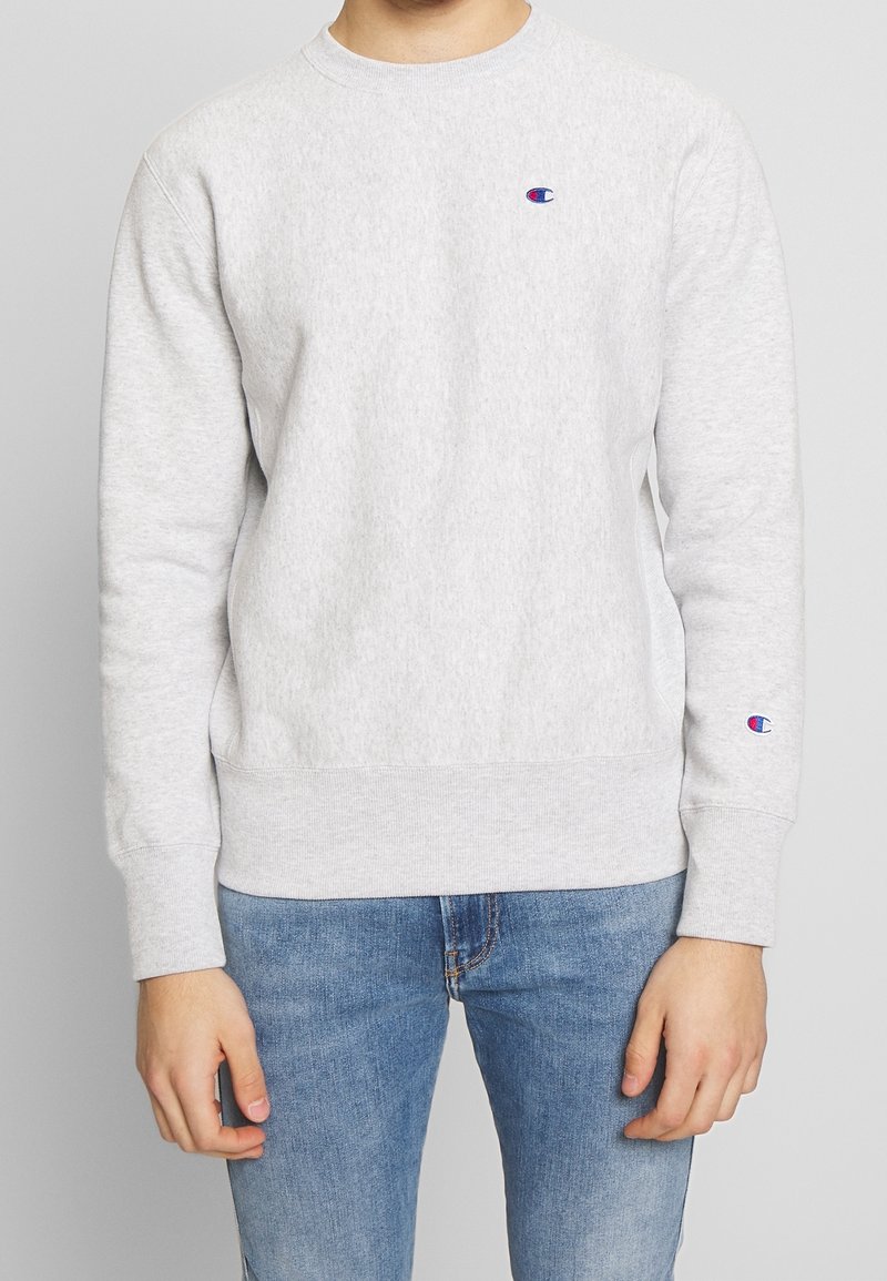 Grauer Sweatshirt mit Rundhalsausschnitt, elastischen Bündchen und Saum, mit einem kleinen gestickten Logo auf der linken Brust und dem linken Ärmel.