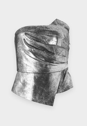 Metallisk sølvfarget strapless topp med en teksturert overflate. Har innsamlet detaljer og en asymmetrisk kant. Laget av et skinnende, lett materiale.
