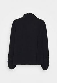 Maglietta nera a maniche lunghe con collo alto, spalle plissettate e dettagli texture ai polsini. Tessuto morbido con una vestibilità rilassata.