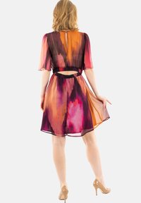 Vestido corto con estampado floral en tonos de naranja, rosa y púrpura. Tejido ligero y transparente, con mangas cortas y cintura elástica.
