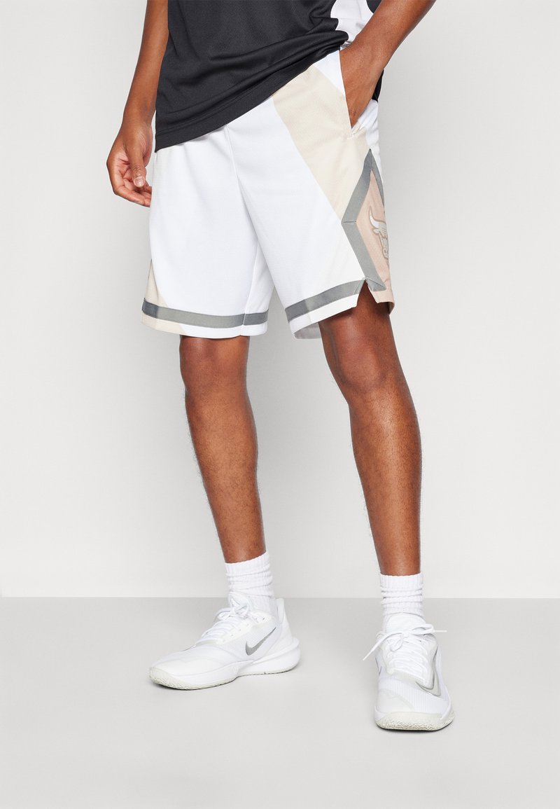 Hvite idrettsshorts med beige og grå detaljer, et trekantet design på siden, og et behagelig, lett stoff.