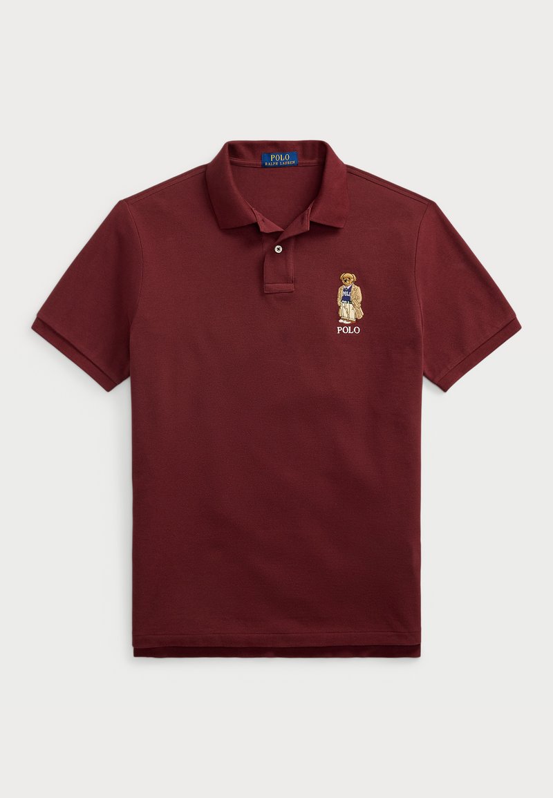 Bordó póló rövid ujjú kialakításban, pamutból készült, hímzett macival, aki kék inget visel és "Polo" logóval.
