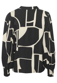 Bluză cu model negru și crem, având un design geometric, mâneci lungi, o croială lejeră și manșete plisate pentru textură și detaliu.