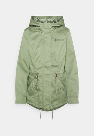 Veste à capuche verte avec une poche poitrine zippée, taille à cordon de serrage et deux poches avant. Tissu lisse avec un design légèrement structuré.