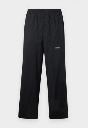 Czarne lekkie spodnie outdoorowe z elastycznym paskiem w talii, przednim guzikiem, dwoma przednimi kieszeniami i małym logo Columbia na prawej nodze.