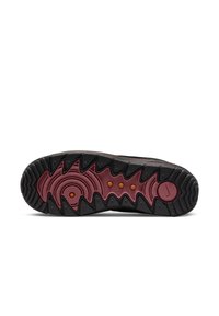 Musta kenkäpohja, jossa on sakaratettu kuviopinta, burgundy- korostus ja kolme oranssia pyöreää elementtiä. Raskaasti teksturoitu kumipinta pitää ottaa kiinni.