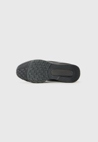 Schwarze Sport-Schuhsohle mit einem strukturierten Profil und geschwungener Form, die auf einer Seite glatt und mit eingeprägten Logo-Details versehen ist.
