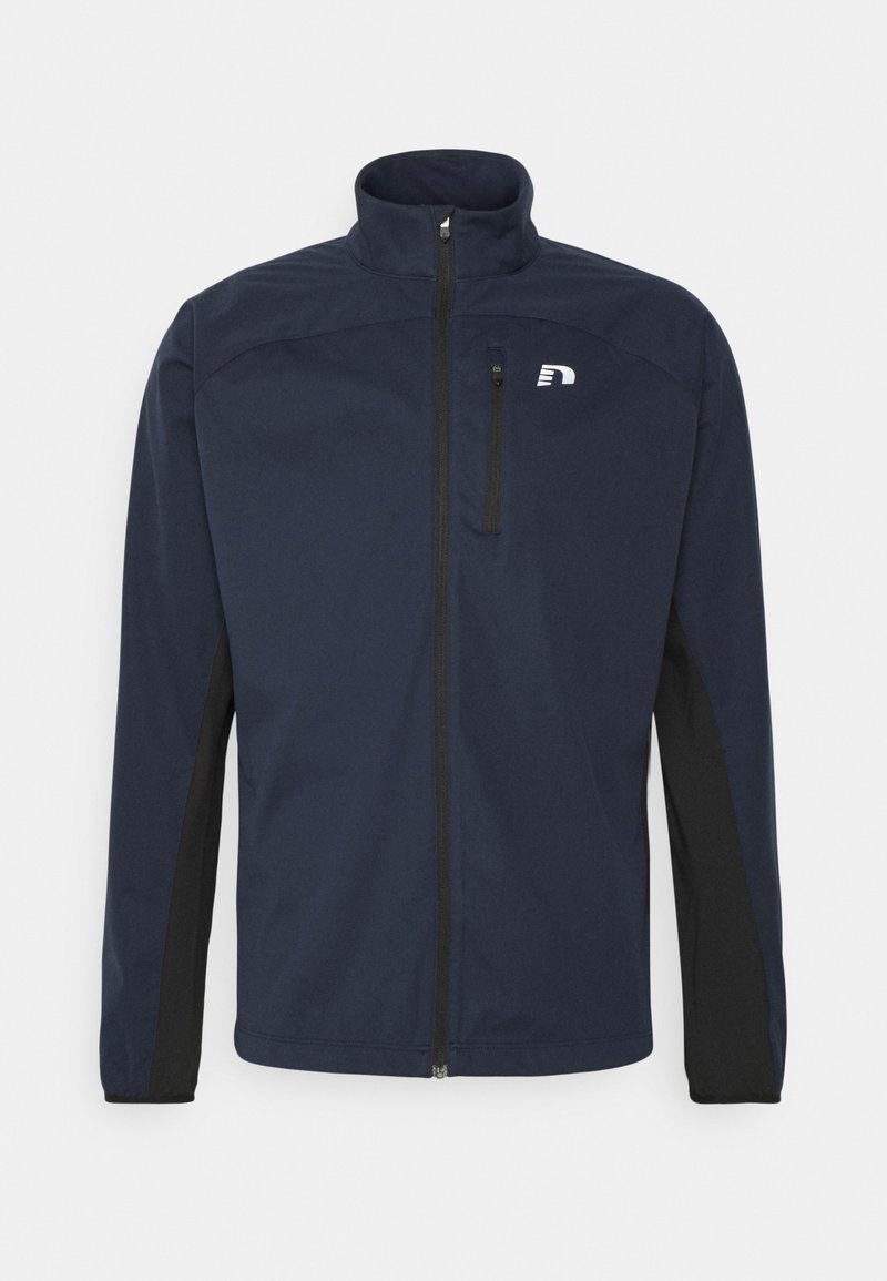 Dunkelblaue Softshelljacke mit Stehkragen, Reißverschluss vorne, schwarzen Seiteneinsätzen und einem kleinen Logo auf der linken Brust.