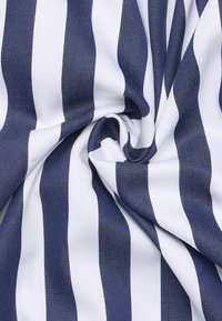 Marineblauwe en witte gestreepte stof met een gladde textuur, met afwisselend gedurfde strepen. De stof is gedraaid om de patronen te tonen.