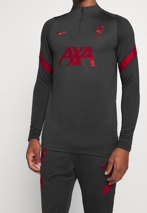 Dunkelgraues Trainingsoberteil mit langen Ärmeln, ausgestattet mit roten Akzenten, einem Viertelreißverschluss und Logos von LFC und Nike. Hergestellt aus strukturiertem Stoff.