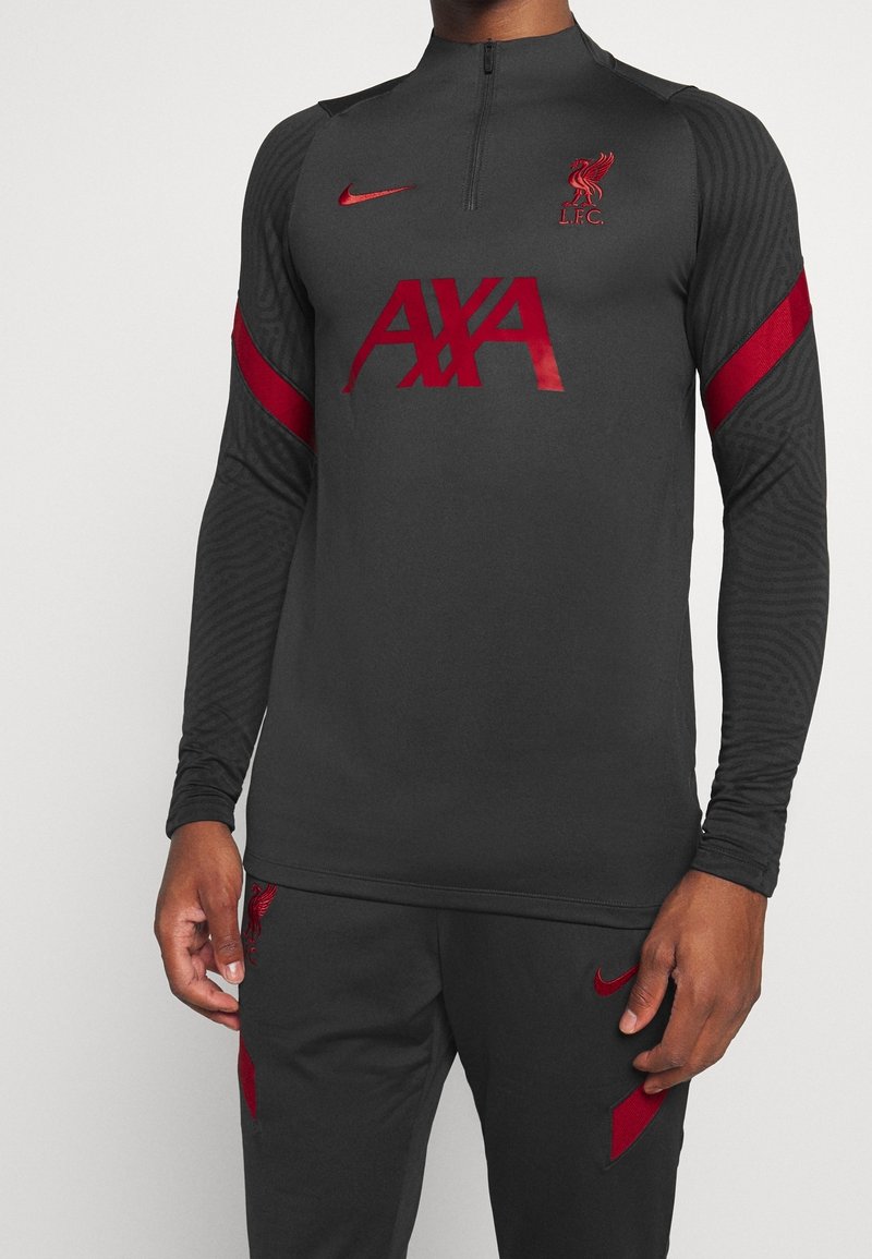 Mørkegrå træningstop med lange ærmer, med røde detaljer, en kvart lynlås og logoer for LFC og Nike. Fremstillet af struktureret stof.
