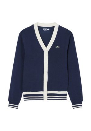 Navy cardigan with a v-neck, cream trim, seven buttons down the front, and a green logo on the left chest. Striped cuffs at the sleeves.