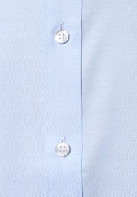 Hellblaues Hemd mit strukturiertem Muster, mit einem weißen Knopf auf der linken Seite und feiner Naht entlang der Kanten.