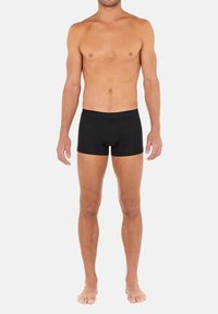 Schwarze Baumwoll-Boxershorts mit einem breiten, elastischen Bund, die eine enganliegende Passform, ein minimalistisches Design und keine sichtbaren Muster oder Akzente aufweisen.