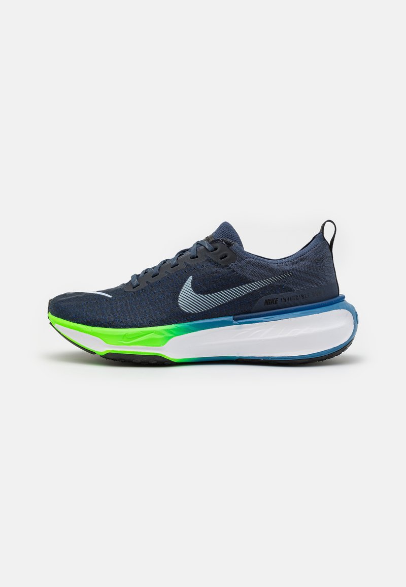 Pantofii de alergare Nike, partea superioară din tricot bleu închis, talpă intermediară verde și albă, talpă texturată, accente reflective, șireturi plate, guler căptușit.