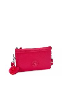 Borsa a tracolla rossa in nylon con superficie texture, chiusura con cerniera e portachiavi a forma di scimmia pelosa rimovibile. Presenta un logo circolare sul davanti.