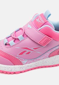 Rosa sneaker med syntetläder och mesh-överdrag, med elastiska snörningar, kardborreband och prickig vit-rosa gummisula.