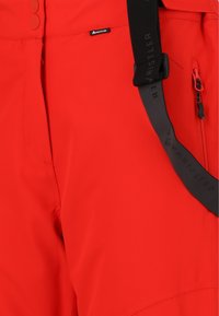 Rode weersbestendige broek met een gladde textuur, zwarte verstelbare banden, zijrits zak en ronde knoopsluitingen.