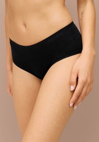 Sorte hipsterundertøj lavet af glat stof, der har et enkelt design med en mellemhøj talje og minimale syninger.