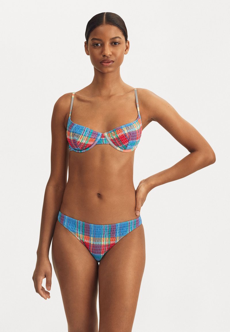 Kleurvolle bikini set met een gestreept top met onderwerkondersteuning en verstelbare bandjes, gecombineerd met bijpassende low-rise onderkant. Textuuroverstof.