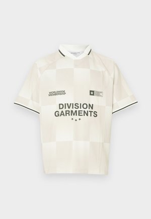 Krémové tričko s krátkym rukávom a kockovaným vzorom, s čiernymi akcentmi a logami, vrátane nápisu "DIVISION GARMENTS" na prednej strane.