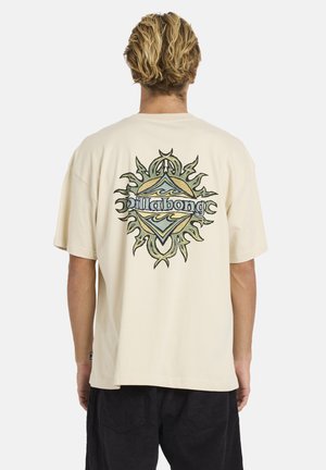 Tricou din bumbac de culoare crem, cu un design grafic multicolor mare pe spate, prezentând modele cu soare și valuri. Croială lejeră.