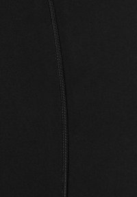 Zwart stof met een gladde textuur en een zichtbare ritsdetail langs de zijkant, wat een slank ontwerp benadrukt.