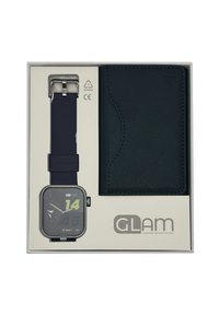 Montre connectée analogique avec un cadran noir carré, accents verts, et un bracelet en silicone bleu marine, accompagnée d'un portefeuille en faux cuir noir dans une boîte blanche.
