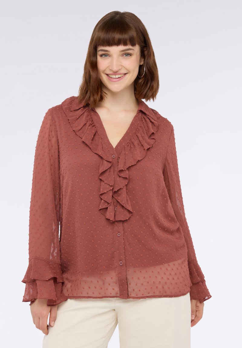 Roestkleurige blouse van lichtgewicht stof, met een gerimpelde kraag en driekwartmouwen met gefronste manchetten en een stippenstructuur.